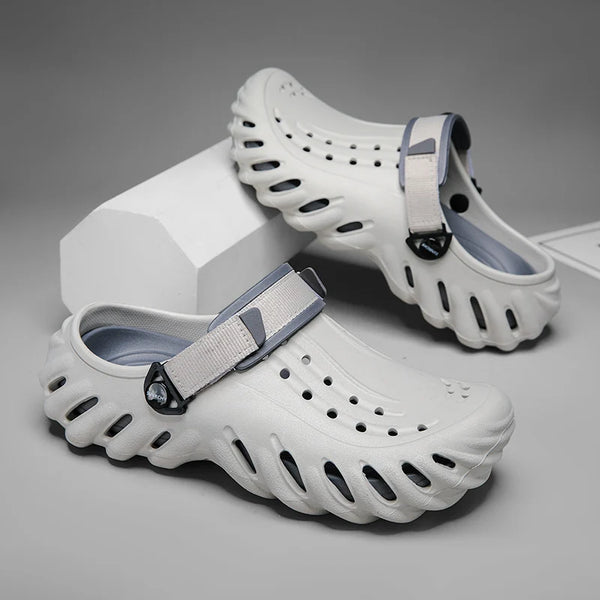 A pair of white durable platform clogs for outdoor and beach use are shown resting on a white block.
