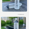 A white collapsible silicone water bottle with a clear cap is shown outdoors on a dark surface.
