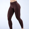 Modelo vistiendo leggings de yoga sin costuras de cintura alta en color marrón oscuro.