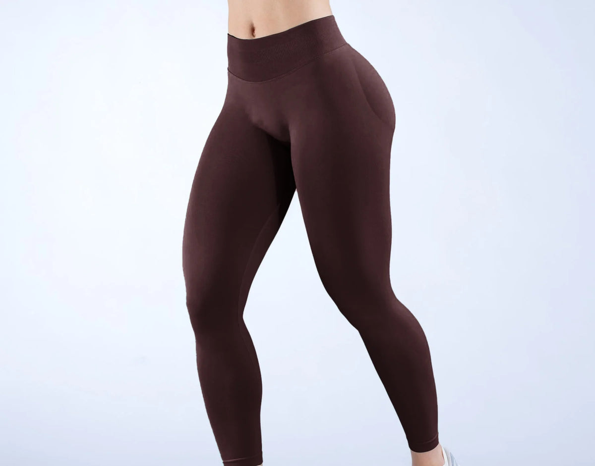 Modelo vistiendo leggings de yoga sin costuras de cintura alta en color marrón oscuro.