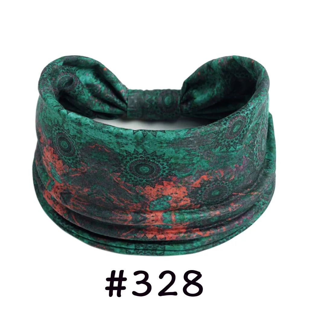 A dark green patterned fabric headband tied in a bow, suitable for yoga or workout.