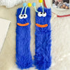 Pair of bright blue cartoon expression knit socks with yellow pom-poms