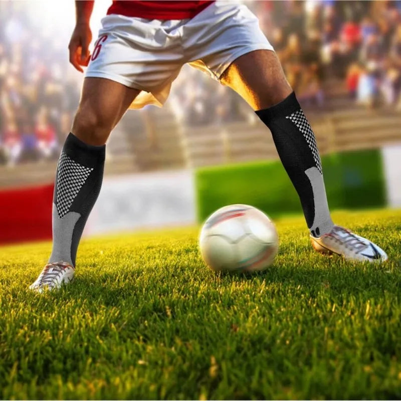 A soccer player wearing compression socks while playing on a green field.