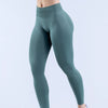 Modelo vistiendo leggings de yoga sin costuras de cintura alta color verde azulado.