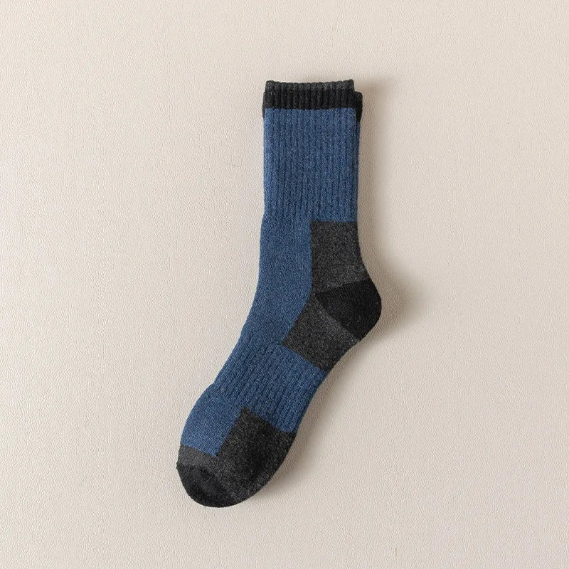 A dark blue merino wool thermal hiking sock with black accents, shown against a light background.