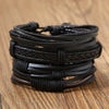 Stapel schwarzer Lederblatt-Feder-Armbänder auf einer Holzoberfläche