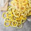 A pile of yellow elastic hair bands in a clear plastic bag