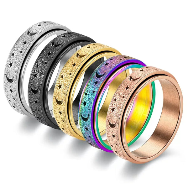 A collection of stainless steel spinning rings featuring various textures and moon and star designs.