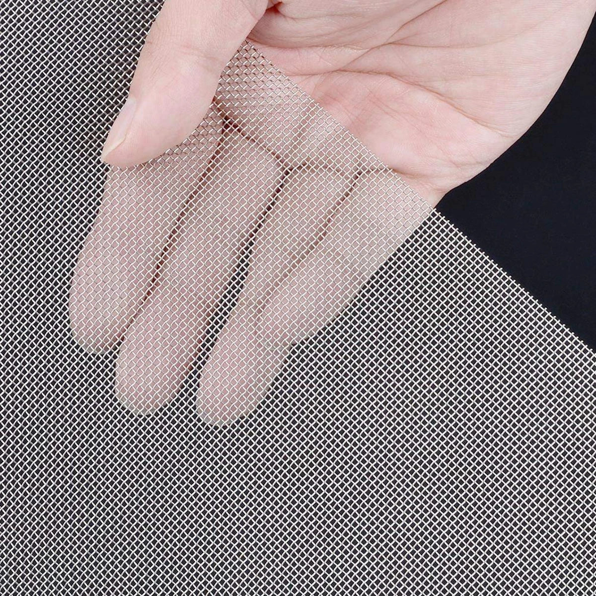 Une main tient des gants à mailles de fil beige clair contre un fond de mailles de fil argenté.