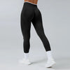Black high-waist yoga leggings with white trim and socks shown on a model.