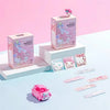 Vendas adhesivas rosas en una caja y varias vendas individuales expuestas sobre una superficie azul claro.