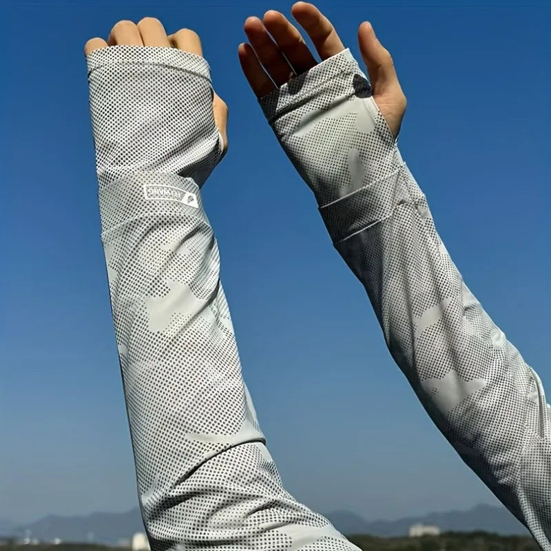 Une personne porte une manche de protection solaire UPF 50+ gris clair à motif sur un fond de ciel bleu.