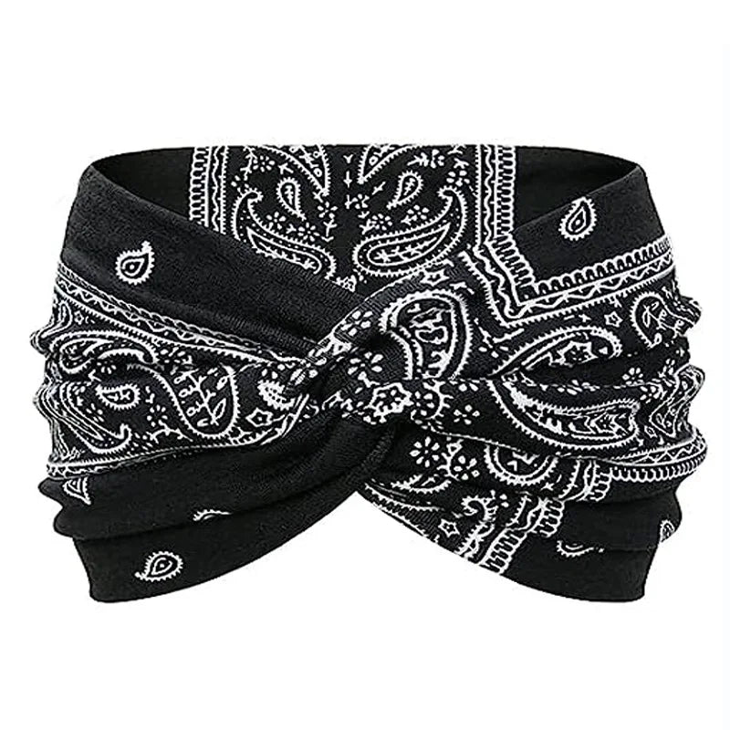 Black fabric yoga headband with white paisley print tied in a bow