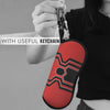 A red eyeglass pouch with a black spider web design attached to a keychain.