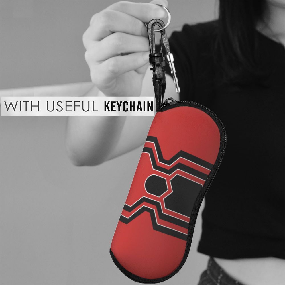A red eyeglass pouch with a black spider web design attached to a keychain.