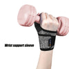 A hand wearing a black wrist support sleeve is holding a pink dumbbell.