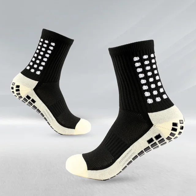 Un par de calcetines deportivos para fútbol negros y blancos antideslizantes para hombres, vistos de lado.