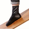 Black elastic PU boots worn on a wooden surface, demonstrating warmth without tightness.