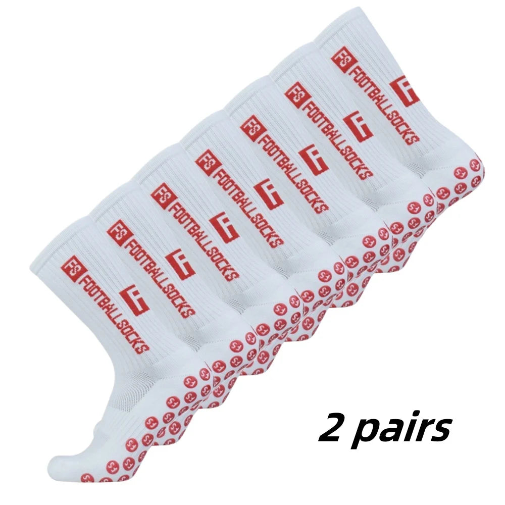 Two pairs of white football socks with red text and grip patterns