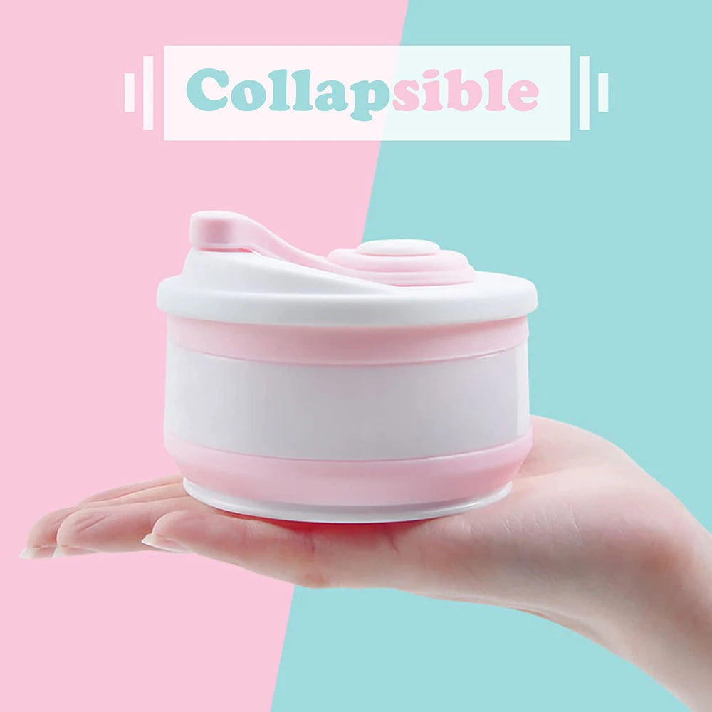 A hand holds a pink silicone collapsible coffee cup with a lid against a light pink and teal background.