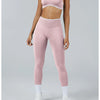 A woman wearing light pink high-waist yoga leggings and a matching sports bra top.