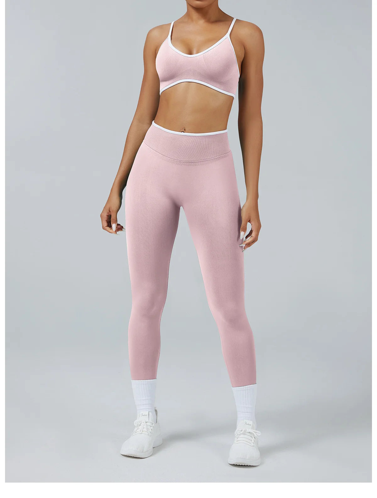 A woman wearing light pink high-waist yoga leggings and a matching sports bra top.