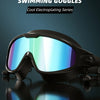 A pair of black swimming goggles with a reflective blue lens resting on a dark surface.