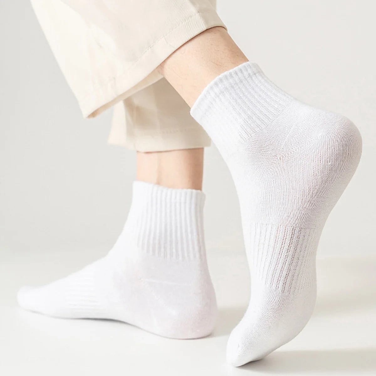 White crew socks being worn by a person, showing the texture and fit of the athletic socks.