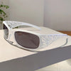 White frame sunglasses with silver rhinestone cat eye detailing resting on a white surface.