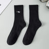 A pair of black men's athletic crew socks with a white embroidered logo on the foot.