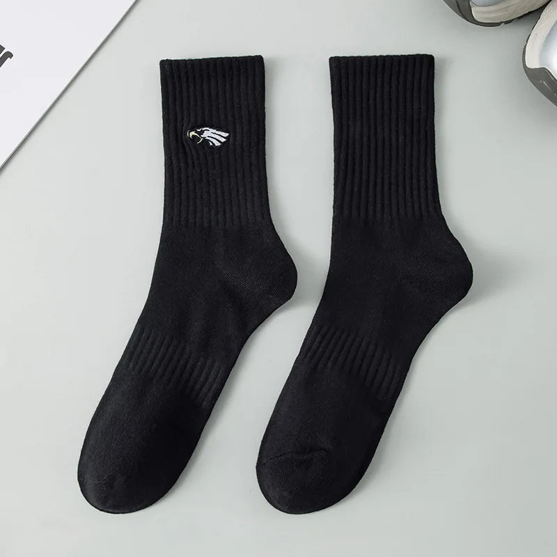 A pair of black men's athletic crew socks with a white embroidered logo on the foot.