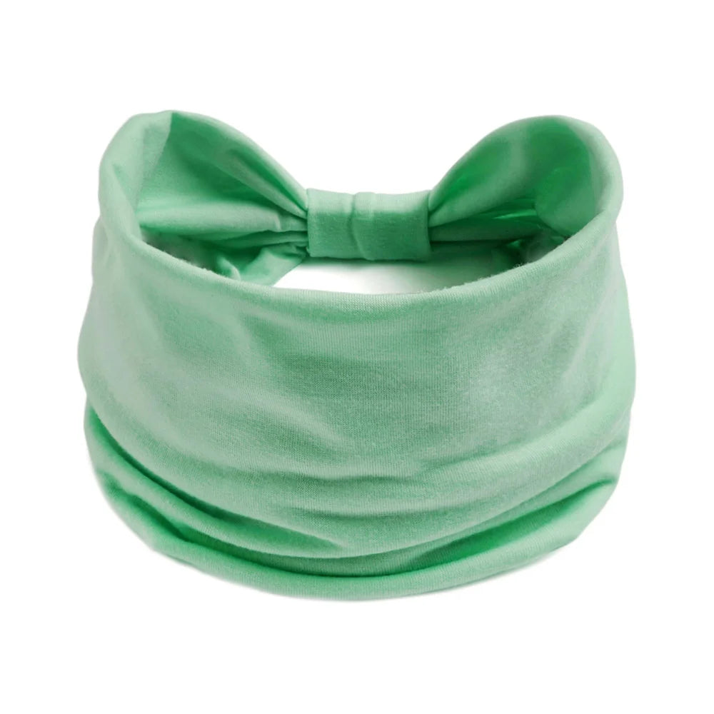 Un foulard en coton bohème vert menthe clair noué en nœud.