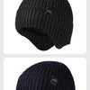 A close-up view of a dark brown knitted winter knit hat shown from the side.