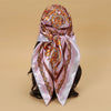 Elegant satin square scarf featuring an ornate floral pattern in pink and gold tones