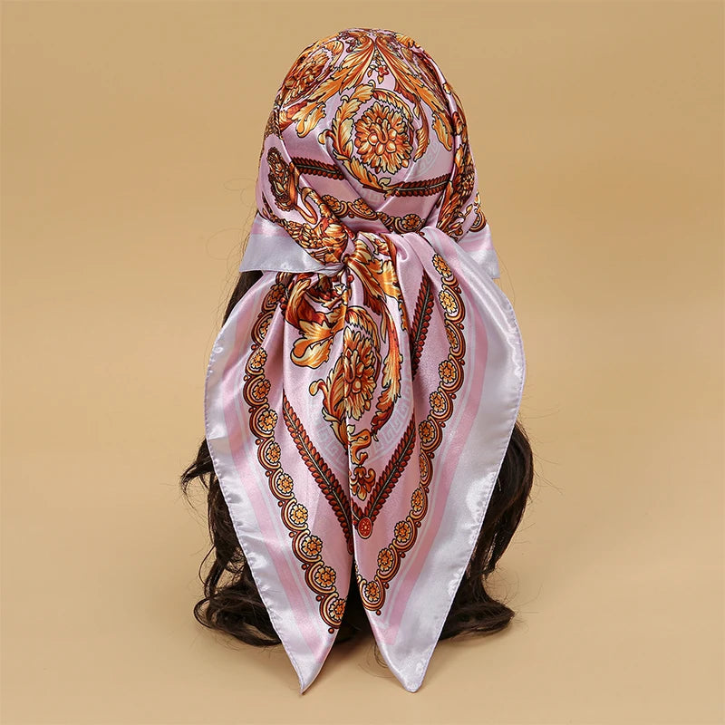 Elegant satin square scarf featuring an ornate floral pattern in pink and gold tones