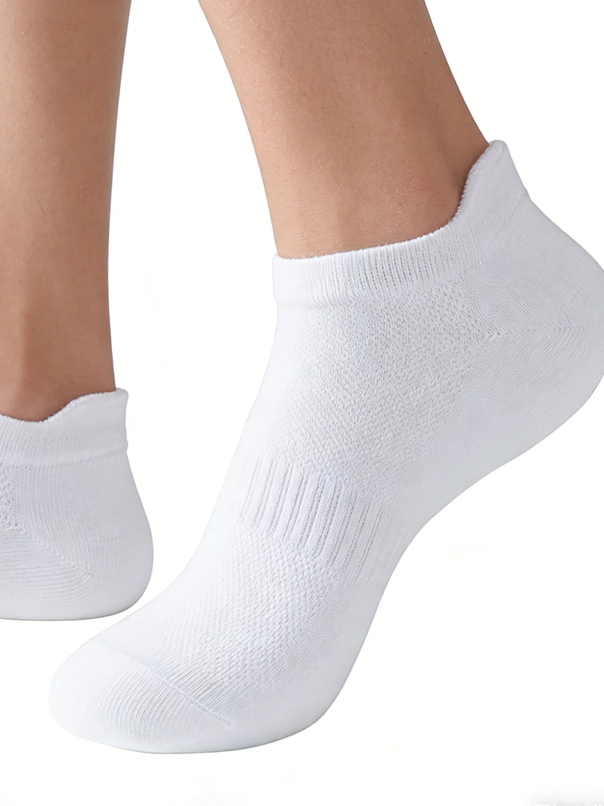 A close-up view of a white knitted ankle sock worn on a foot.