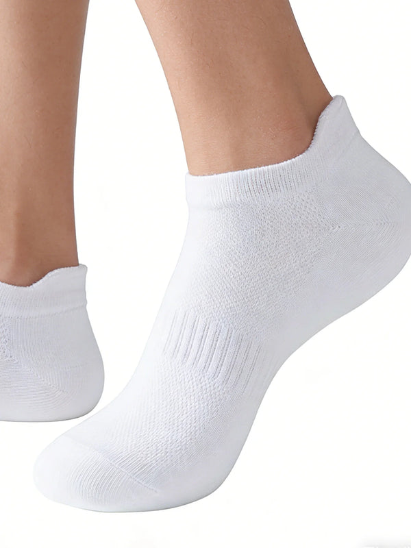 A close-up view of a white knitted ankle sock worn on a foot.