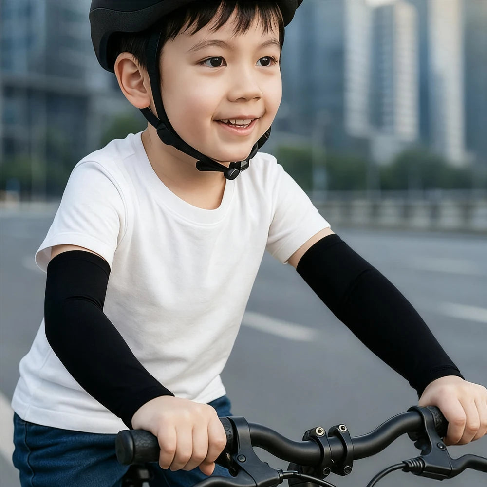 Lächelnder Junge in weißem T-Shirt und schwarzen Kompressionsärmeln beim Fahrradfahren.