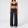 A woman wearing a black women's premium fitness tracksuit top and matching pants.