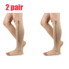 A pair of beige compression stockings with zippers shown on legs.