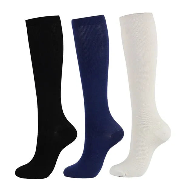 Three pairs of compression socks in black, navy blue, and white.