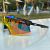 A pair of orange and purple tinted sports sunglasses resting on a white surface.