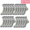 20 paires de chaussettes en tricot gris, mi-mollet et respirantes, disposées en rangée.