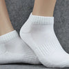 Un par de calcetines de punto blancos mostrados en el pie de una modelo.