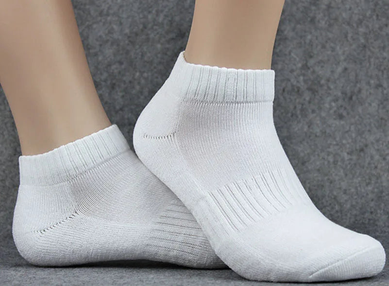 Un par de calcetines de punto blancos mostrados en el pie de una modelo.