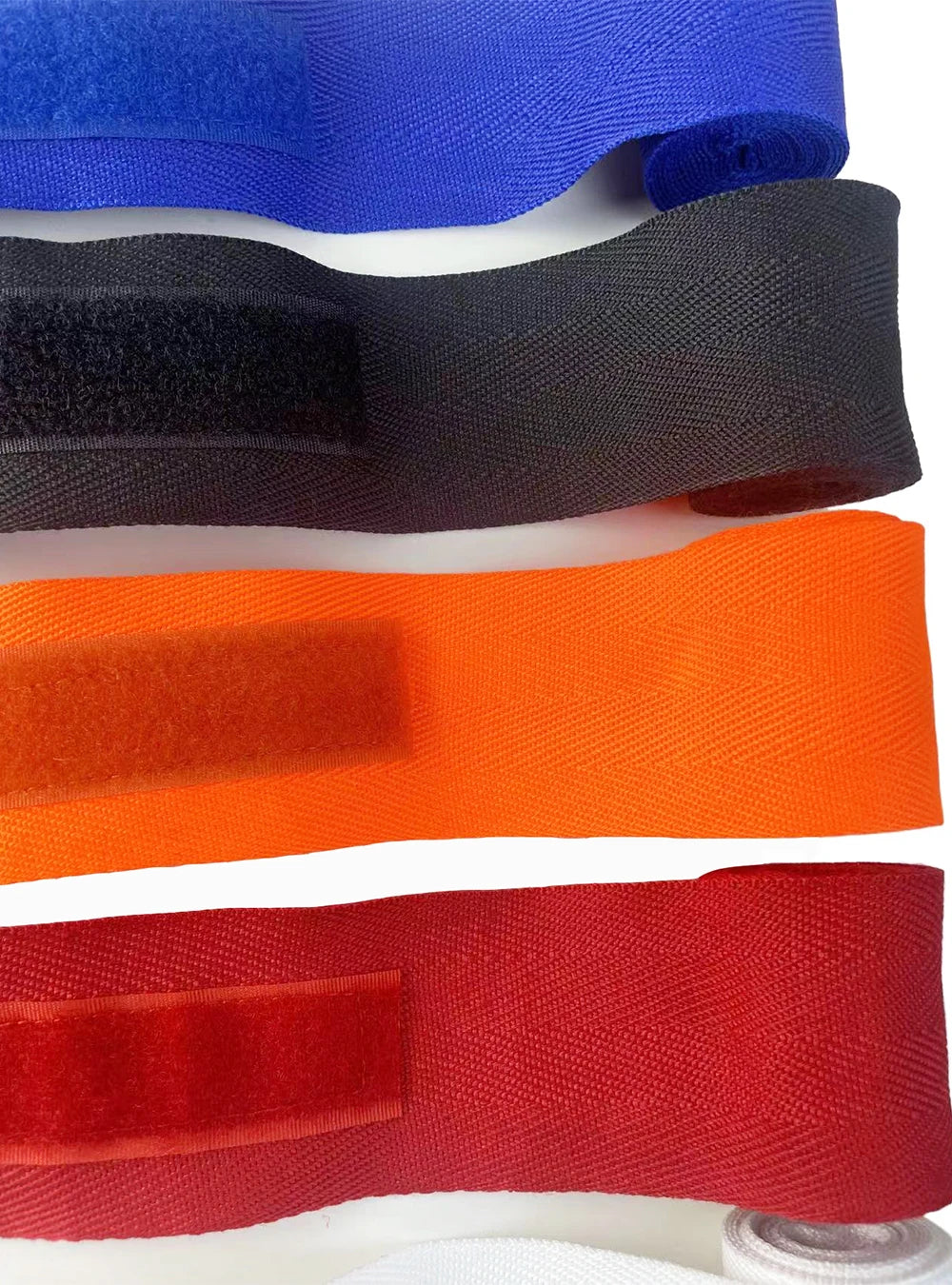 A collection of various colored boxing hand wraps laid out horizontally.