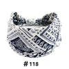 A close-up of a white and navy boho print cotton headband tied around a head.