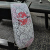 A weightlifting belt featuring a design of a red flower and swirling black and pink patterns.