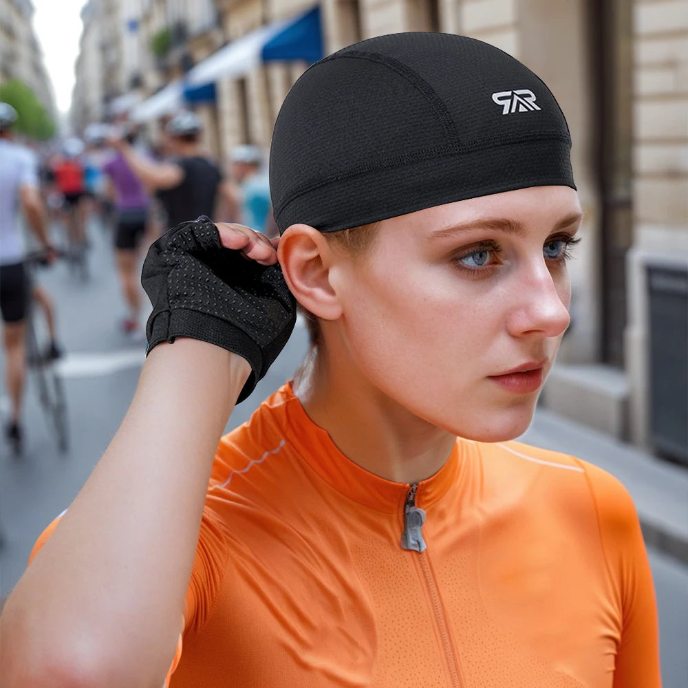 A woman wearing an orange cycling top and a black cap is shown outdoors on a city street.