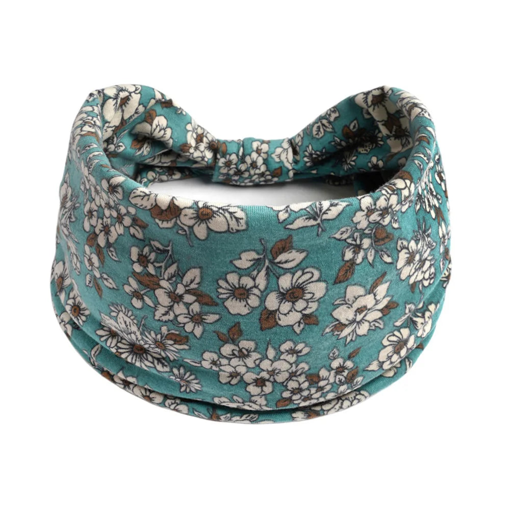A teal cotton stretch headband tied in a bow with a floral print.